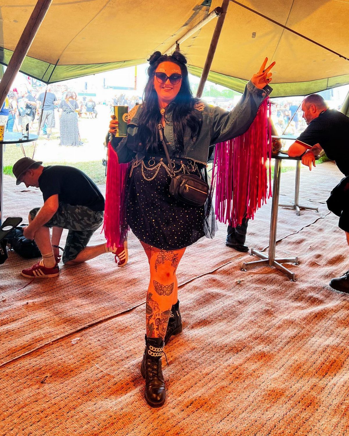 Plus Size Festival Outfits: 9 Looks You'll Want to Wear 3 Woman in a black dress and pink fringe jacket posing at a festival