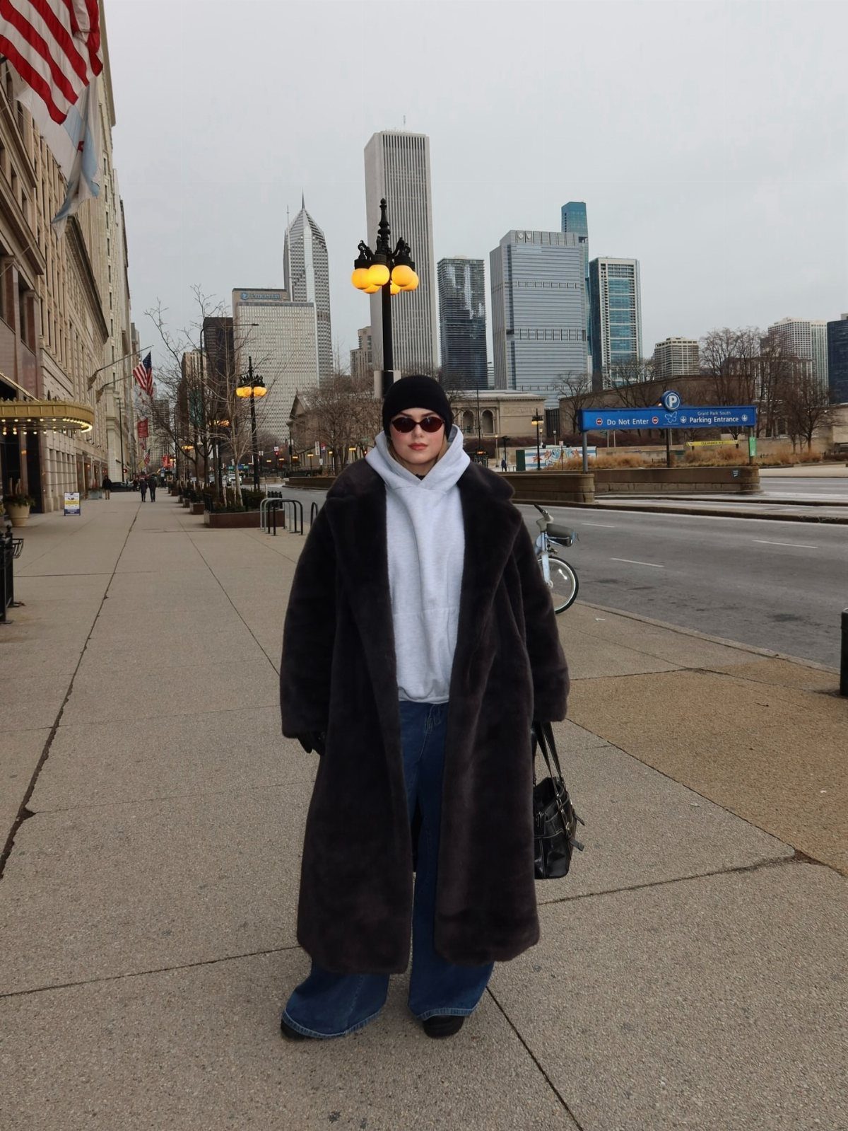 Plus Size Winter Outfits: 7 Cozy and Stylish Looks to Try 5 Plus-size person wearing a long brown faux fur coat and white hoodie in a city.