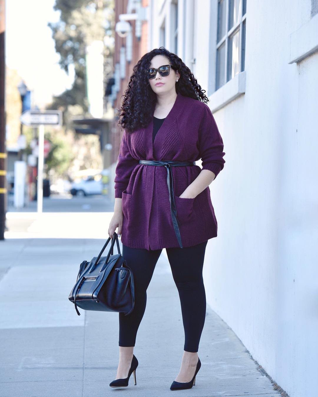 Plus Size Winter Outfits: 7 Cozy and Stylish Looks to Try 1 Woman wearing a chunky purple knit cardigan with a belt and black leggings.