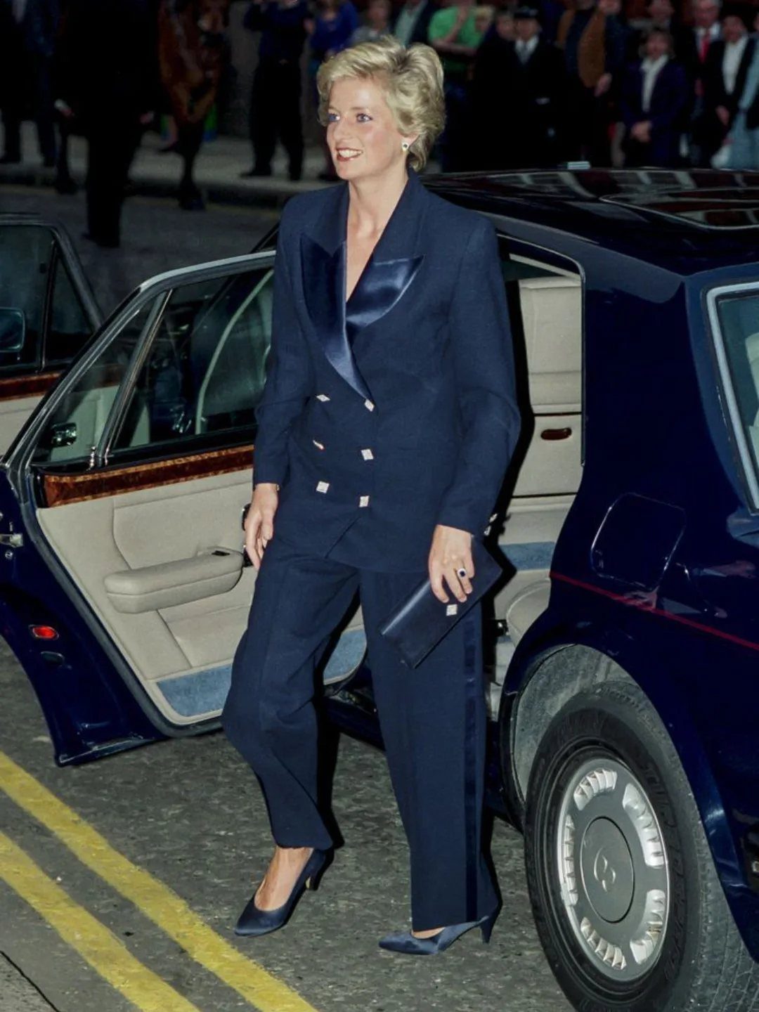 Princess Diana Outfits That Defined Royal Style (11 Ideas) 5 Princess Diana wearing a navy blue double-breasted power suit and matching trousers.