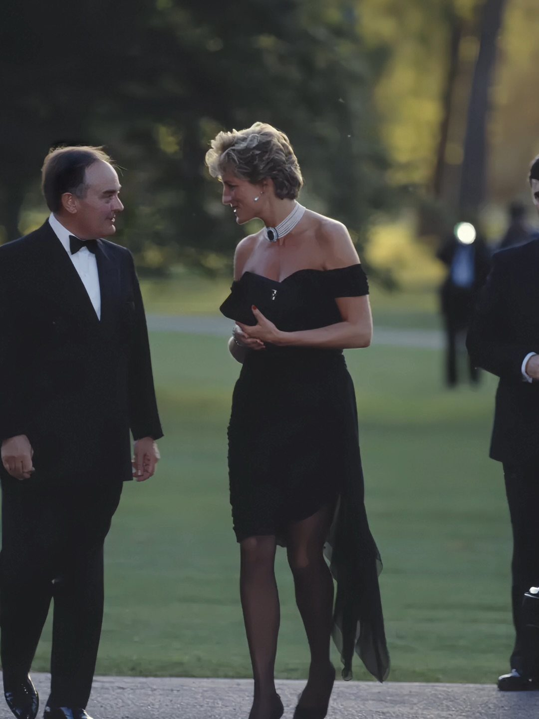 Princess Diana Outfits That Defined Royal Style (11 Ideas) 1 Princess Diana wearing the iconic black off-the-shoulder revenge dress and a sparkling choker.
