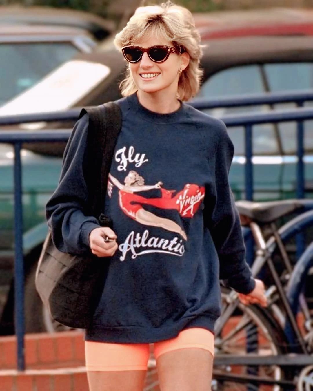 Princess Diana Outfits That Defined Royal Style (11 Ideas) 8 Princess Diana wearing a navy blue sweatshirt and peach biker shorts outdoors.