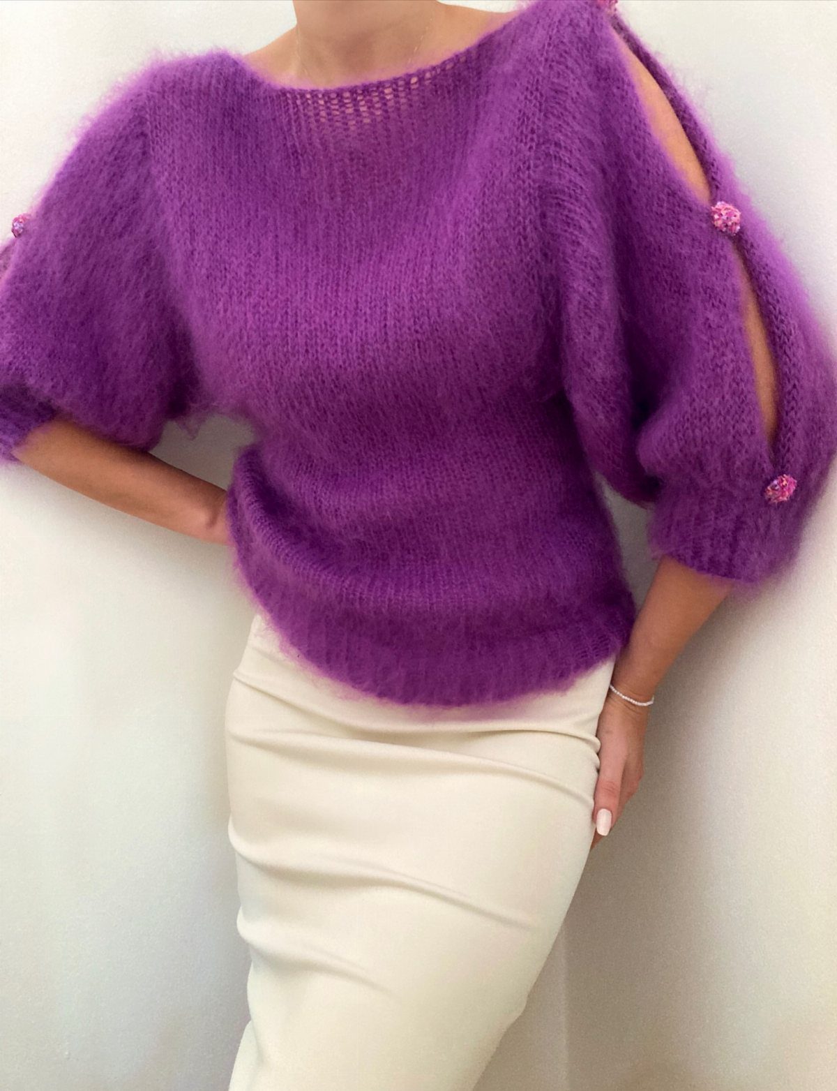 Purple Winter Outfits: 9 Ways to Style the Season's Boldest Color 2 Purple fuzzy knit sweater with open sleeves paired with a cream pencil skirt.