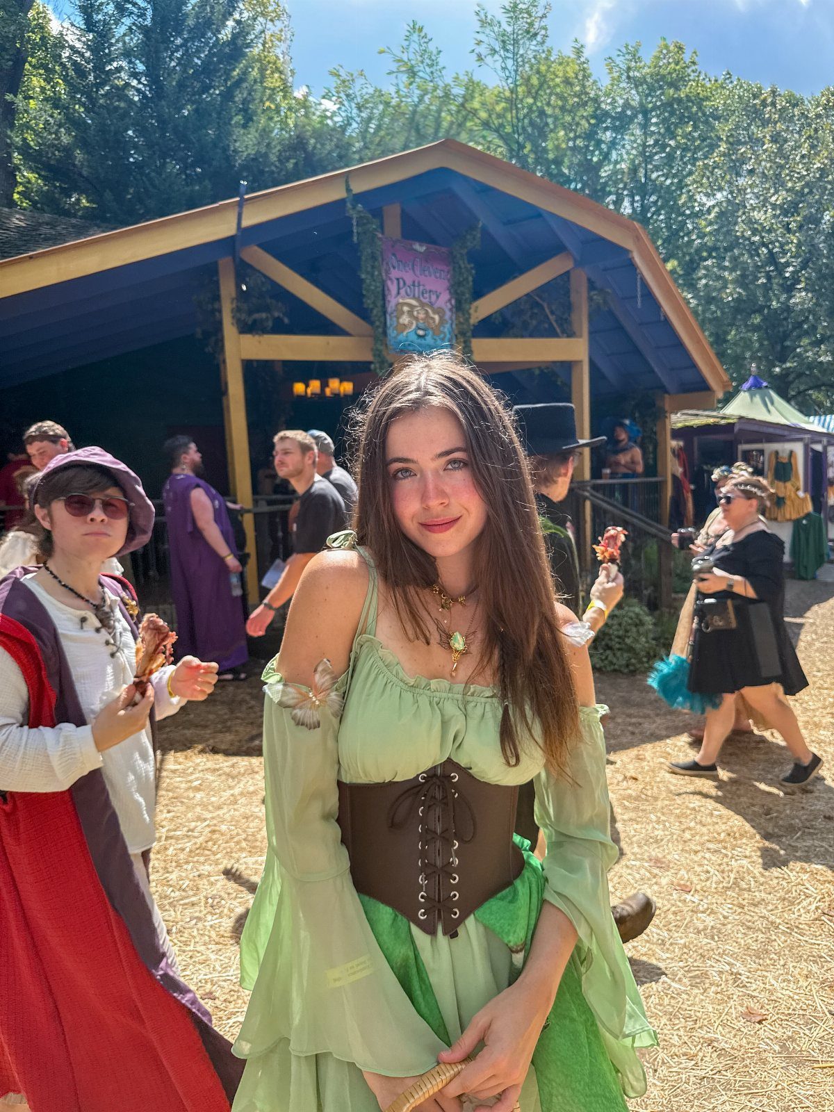 Renaissance Fair Outfits Women Can Wear: 12 Looks 2 Woman in a green peasant dress and brown corset at a renaissance fair.