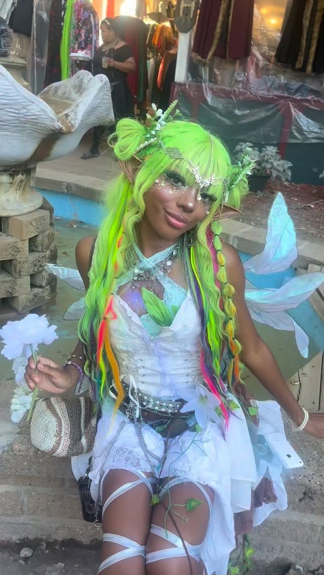 Renaissance Fair Outfits Women Can Wear: 12 Looks 3 Woman with neon green hair wearing a white fairy costume with iridescent wings