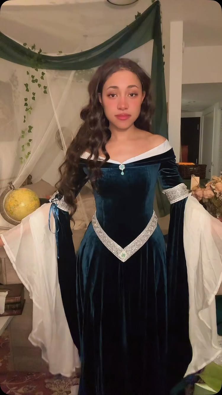 Renaissance Fair Outfits Women Can Wear: 12 Looks 6 Woman in a dark teal velvet Renaissance lady gown with flowing white sleeves.
