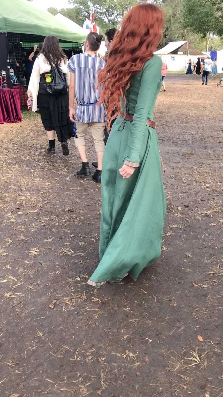 Renaissance Festival Outfits: 8 Ideas from Peasant to Princess 3 Woman with long red hair wearing a long green medieval dress at a festival