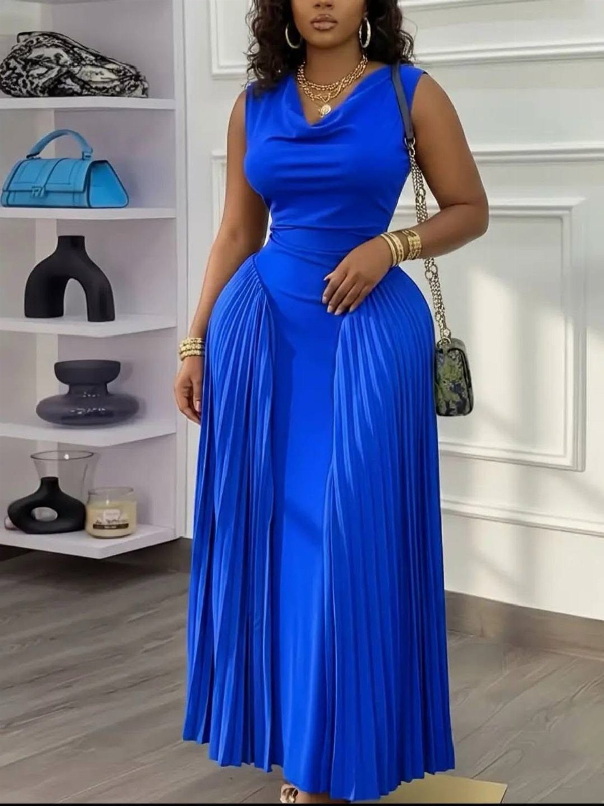 Royal Blue Outfits in 8 Styles for Every Occasion 8 Woman wearing a royal blue sleeveless maxi dress with a pleated skirt and gold jewelry.