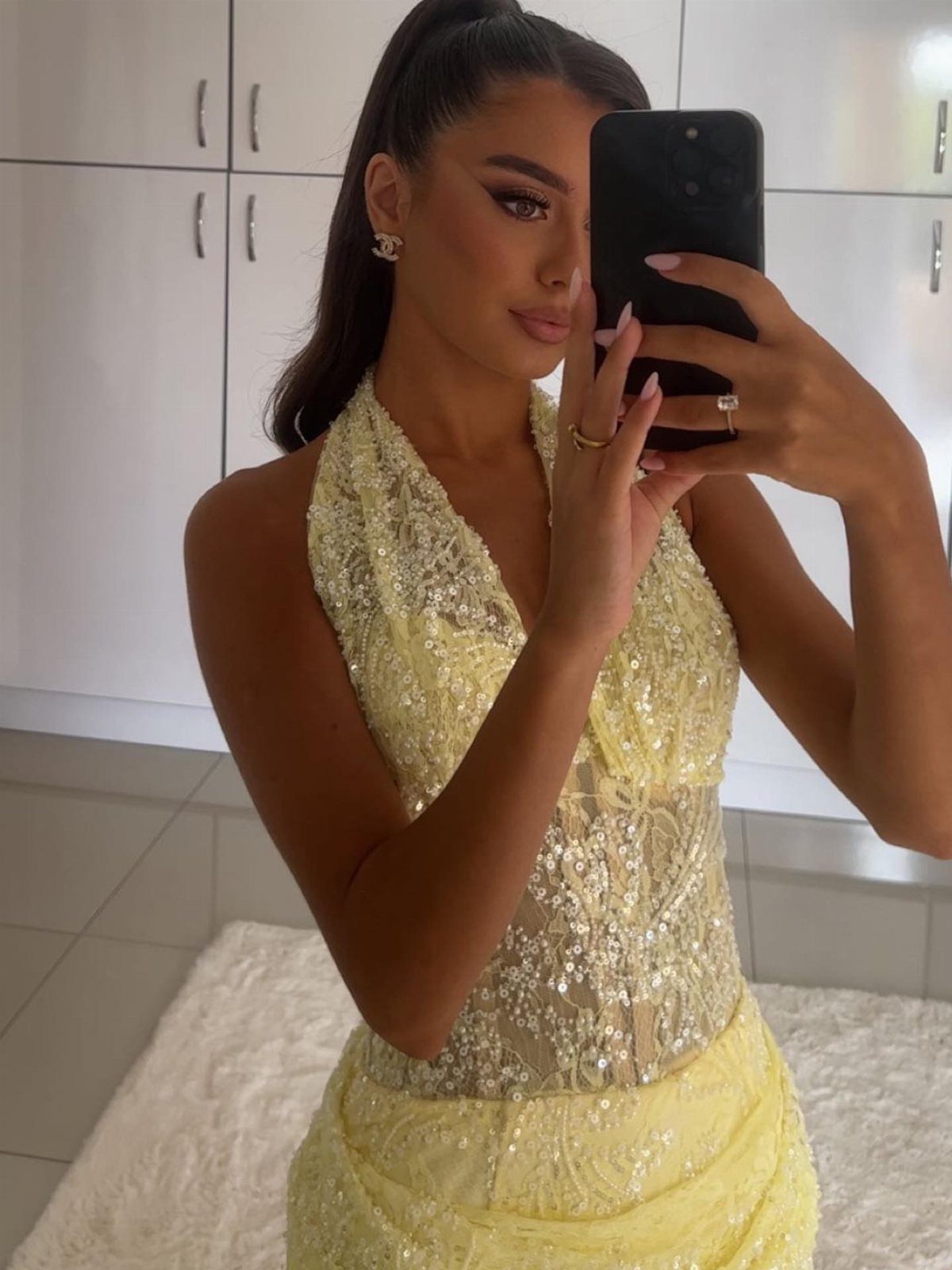 14 Serena van der Woodsen Outfits That Defined Gossip Girl Style 3 Woman in a sequined pale yellow evening gown taking a mirror selfie.