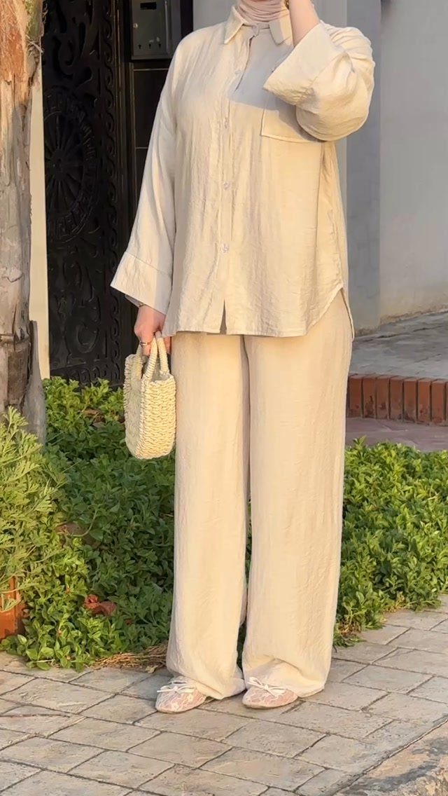8 Summer Hijab Outfits for Modest, Breathable Style 7 Woman in a beige linen co-ord set and hijab holding a straw bag.