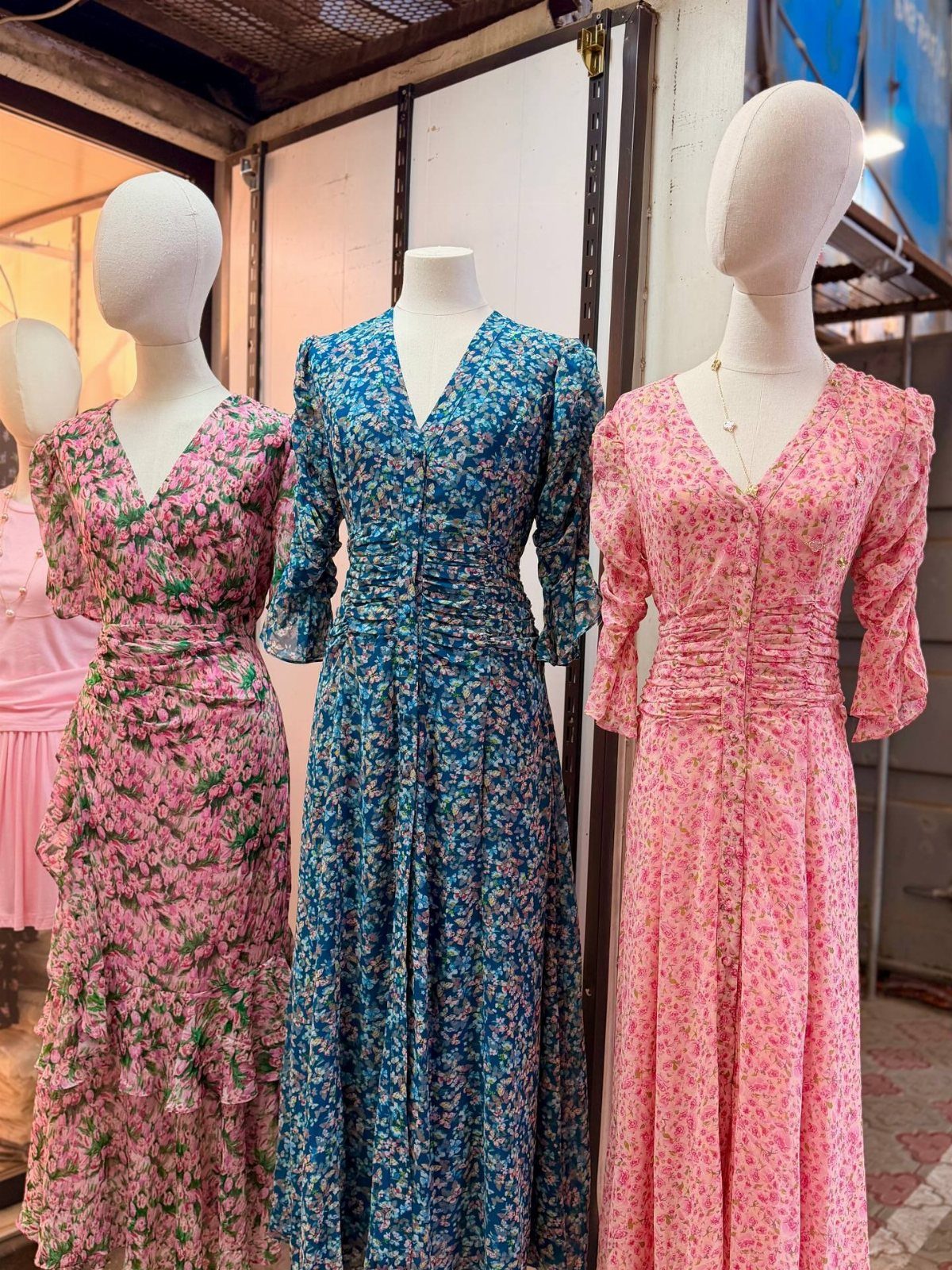 Summer House Outfits: 10 Effortless Ideas for Weekends Away 7 Three floral print maxi dresses in pink and blue on white mannequins.
