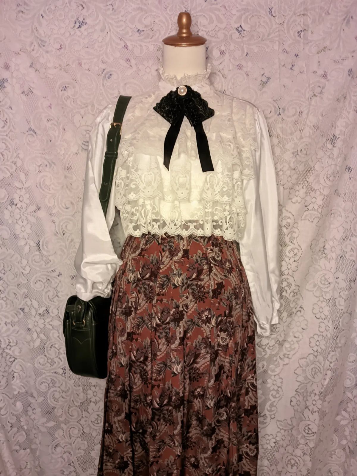 Tea Party Outfits for Adults: 10 Ideas from Garden to High Tea 7 White lace blouse with black bow and brown floral midi skirt on mannequin.