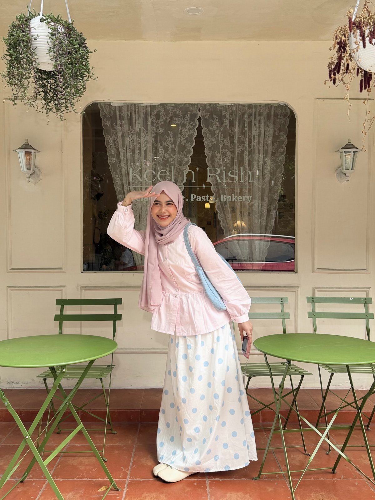 Tea Party Outfits for Adults: 10 Ideas from Garden to High Tea 3 Woman in pink blouse and blue polka dot skirt standing by green cafe tables.