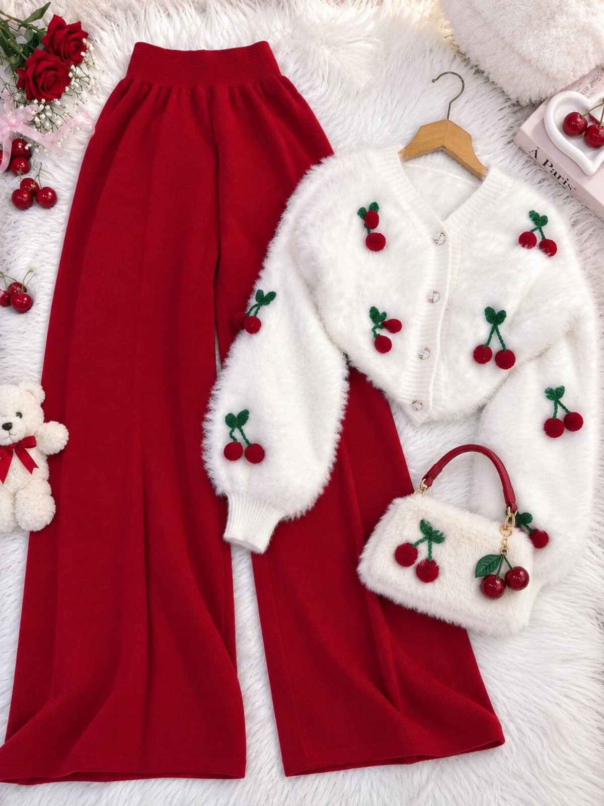 Twice This Is For Outfits: 6 Concert-Ready Looks to Recreate 4 Red wide-leg trousers and a white fuzzy cherry-patterned cardigan and handbag on white fur.