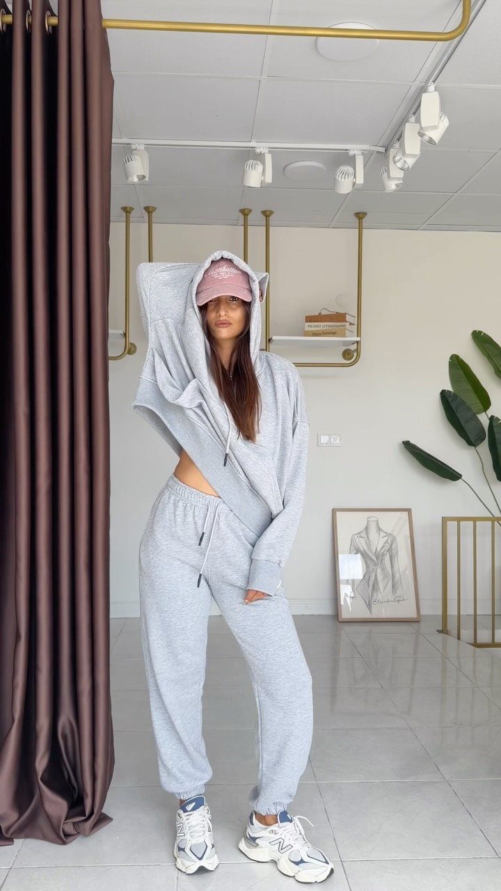 Twice This Is For Outfits: 6 Concert-Ready Looks to Recreate 5 Woman in a grey oversized sweatsuit and pink cap posing in a bright room