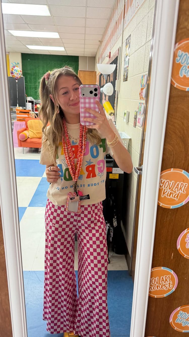 7 Wacky Wednesday Outfits for School, Work & Beyond 5 Woman in a classroom wearing a graphic t-shirt and red checkered wide-leg pants.