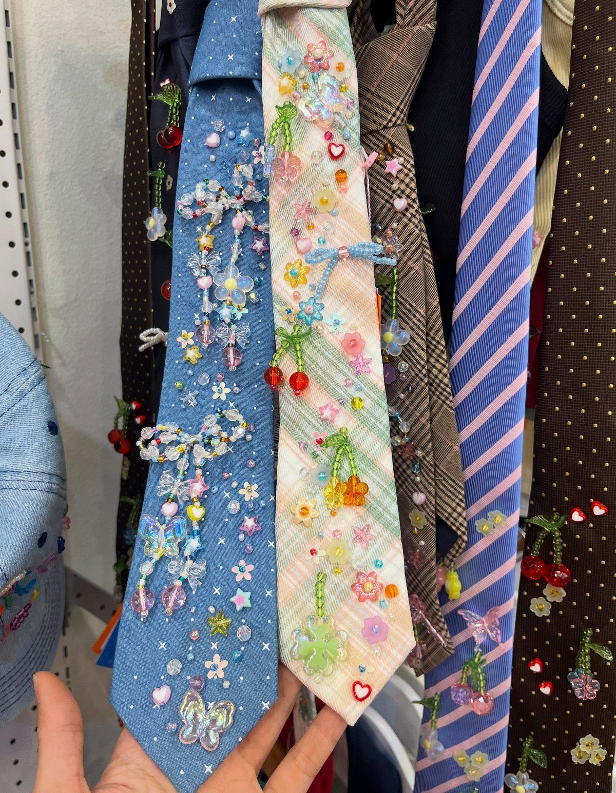 7 Wacky Wednesday Outfits for School, Work & Beyond 2 Beaded and sequined neckties with colorful charms and plastic fruits hanging in a row.