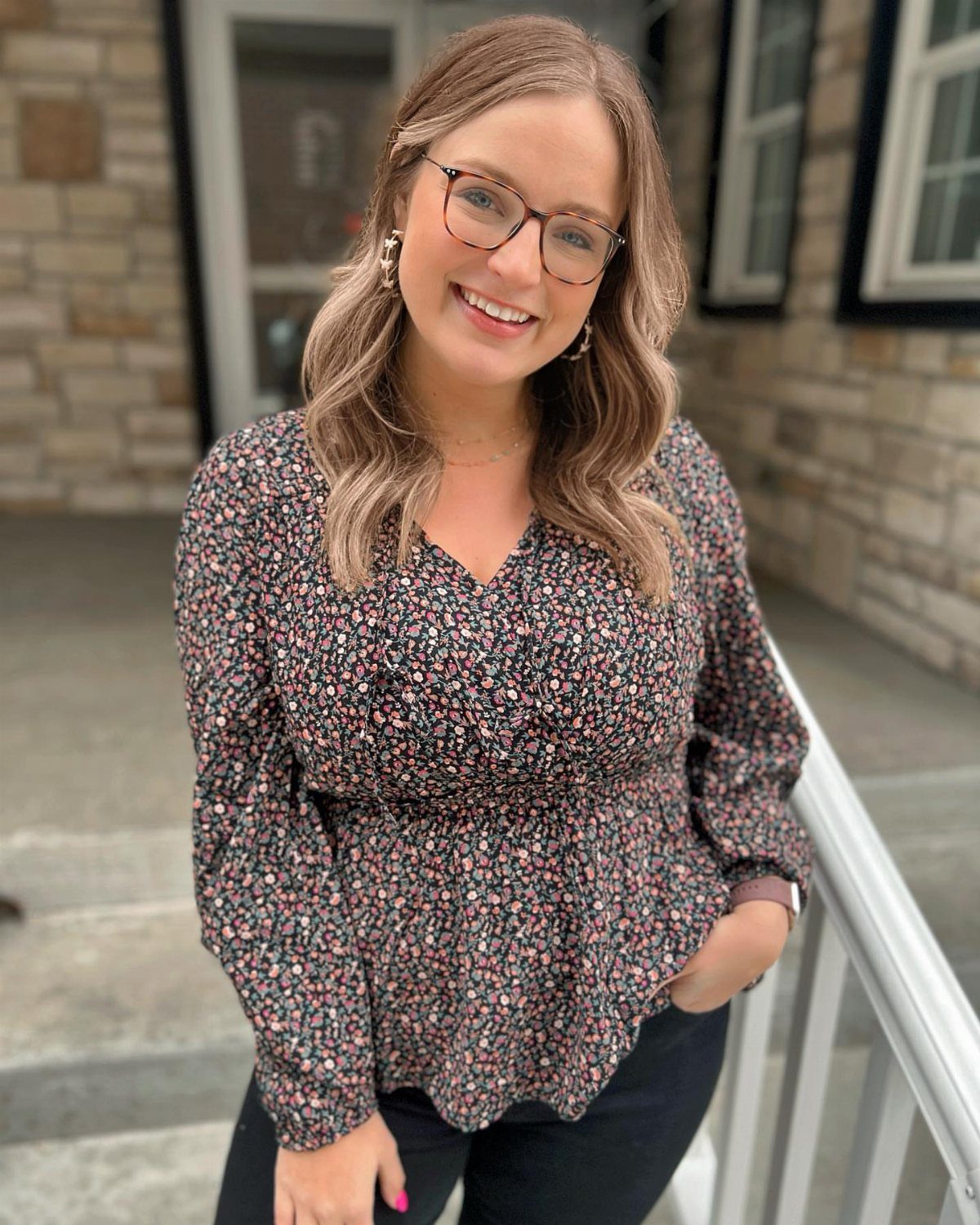 Walmart Spring Outfits: 10 Fresh Ideas for Women This Season 1 Woman wearing a floral print peplum top and black pants standing outdoors.