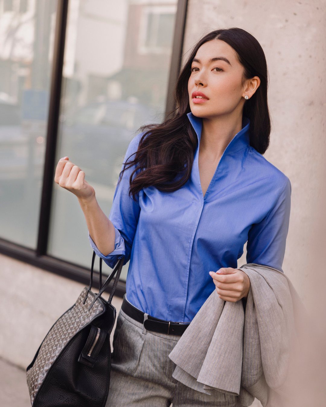 Washington DC Outfits: 11 Stylish Ideas for Your Trip 2 Woman wearing a bright blue button-up shirt and grey trousers standing outdoors.