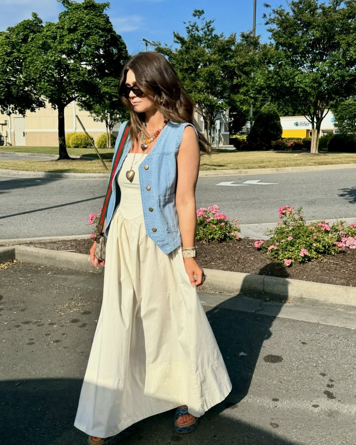 Washington DC Outfits: 11 Stylish Ideas for Your Trip 3 Woman wearing a long cream lightweight dress and a sleeveless denim vest outdoors.