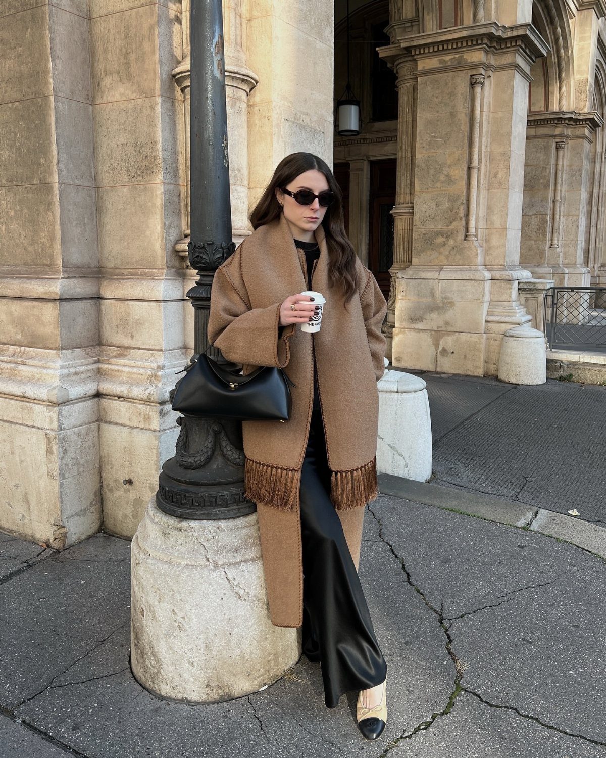 Women's Scarf Coat: 12 Ideas to Try This Season 4 Woman in a camel-colored wool scarf coat with fringe and black leather pants.