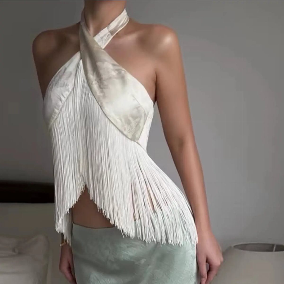 13 Zara Holiday Outfits for Parties and Celebrations 7 White satin halter top with long fringe paired with a light blue satin skirt.